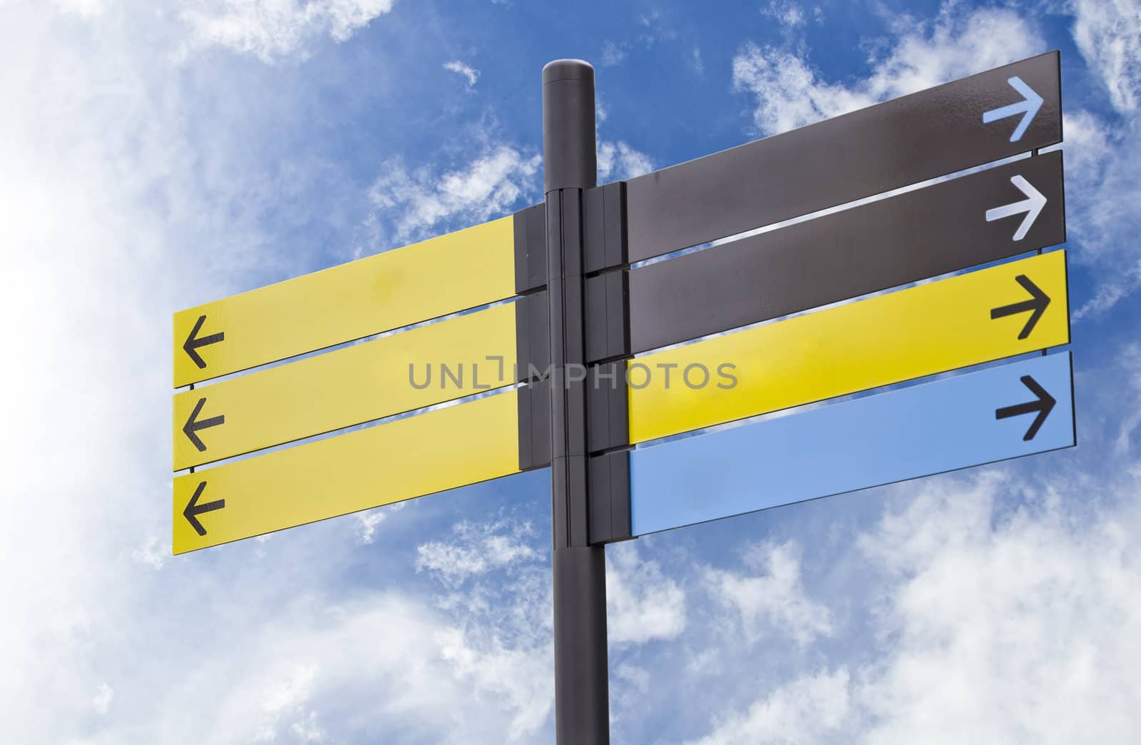 Colorful plastic informational signs with arrows. Show the direction. Against the blue sky with clouds