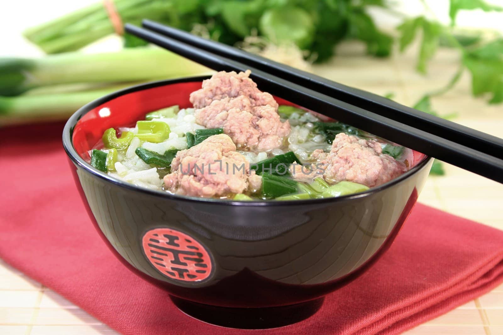 Thai rice soup with meat balls, jasmine rice and spring onions