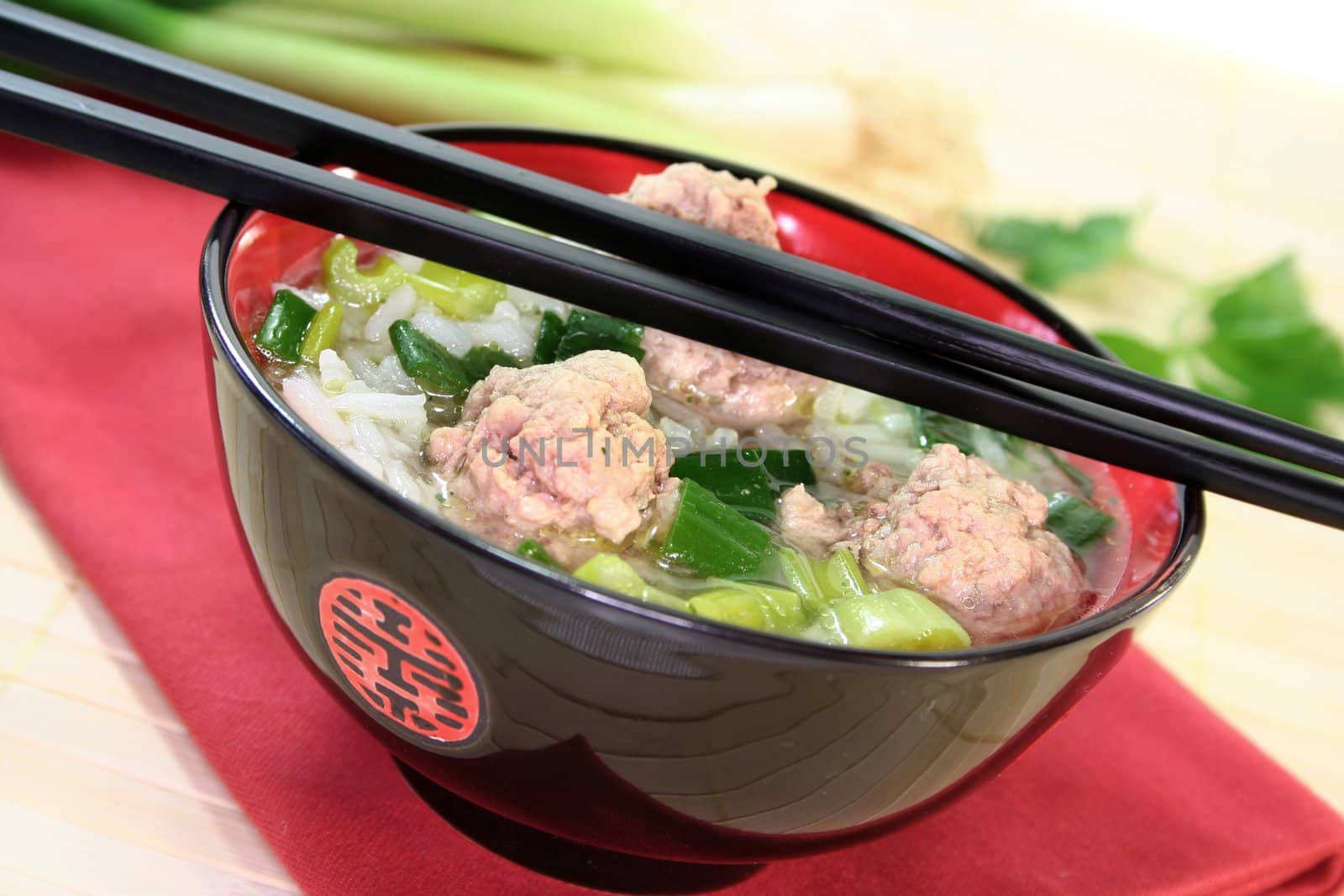 Thai rice soup with meat balls, jasmine rice and spring onions