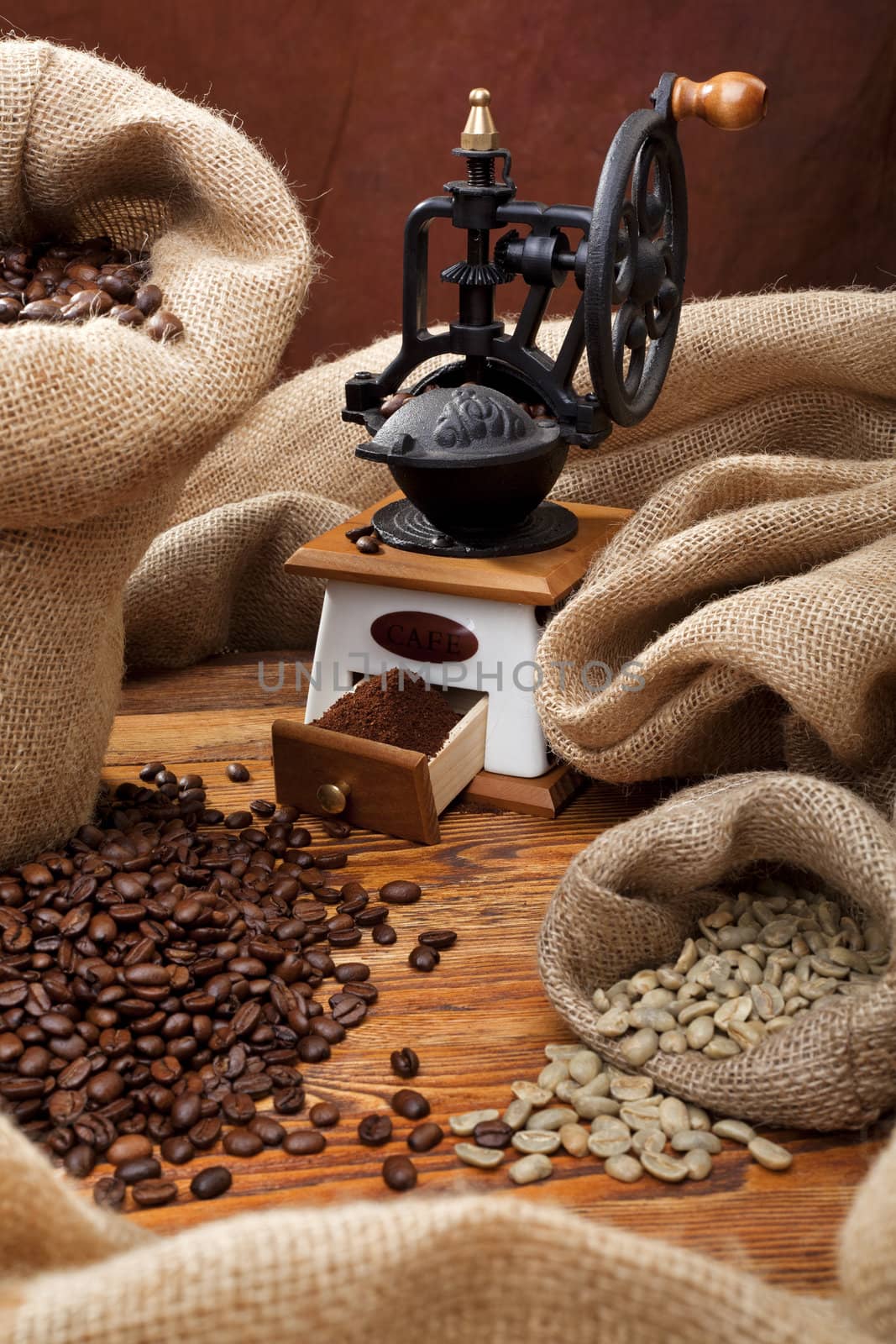 Studio photo of sack with scattered coffee and grinder