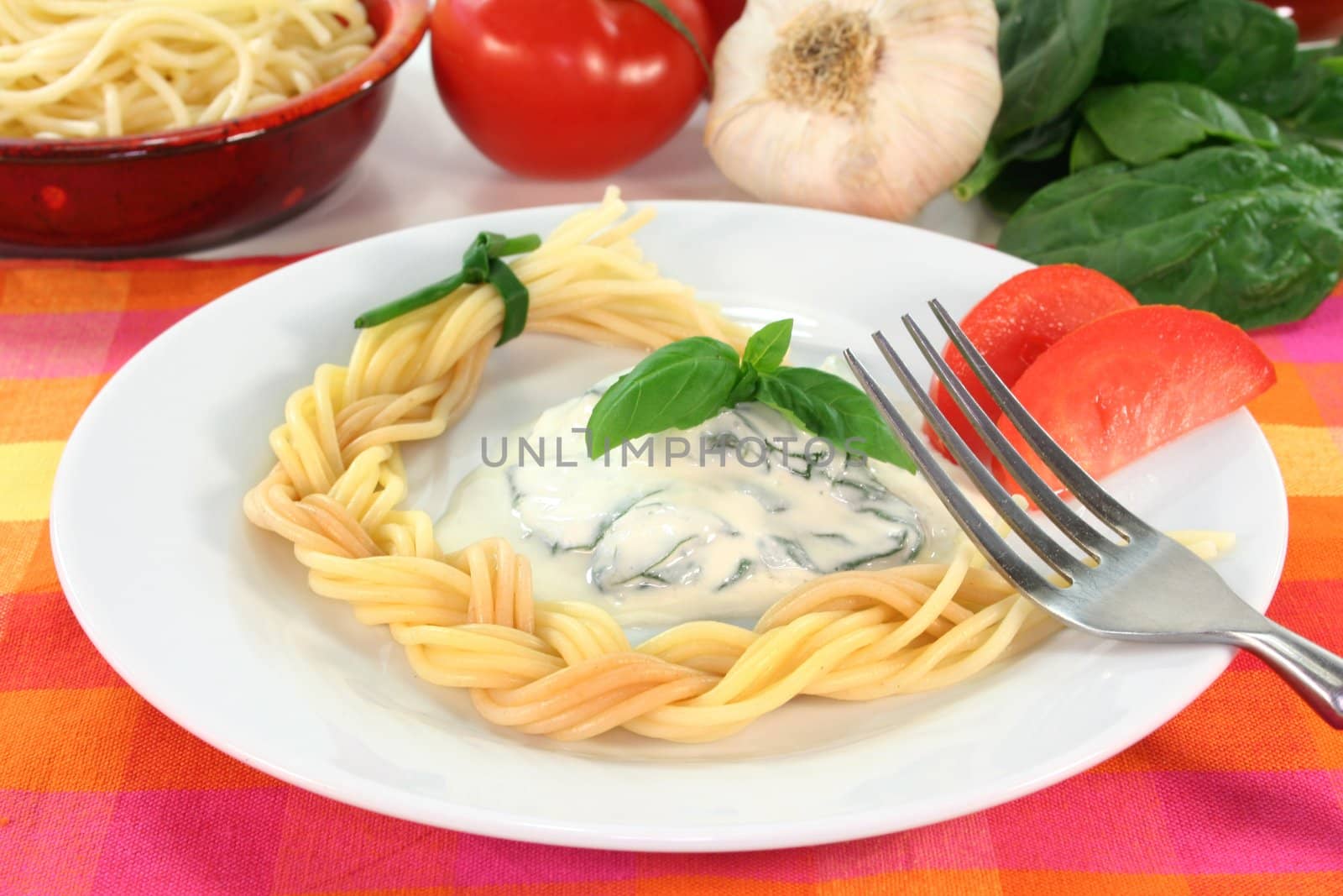 a pasta plait with spinach and cheese sauce with fresh ingredients