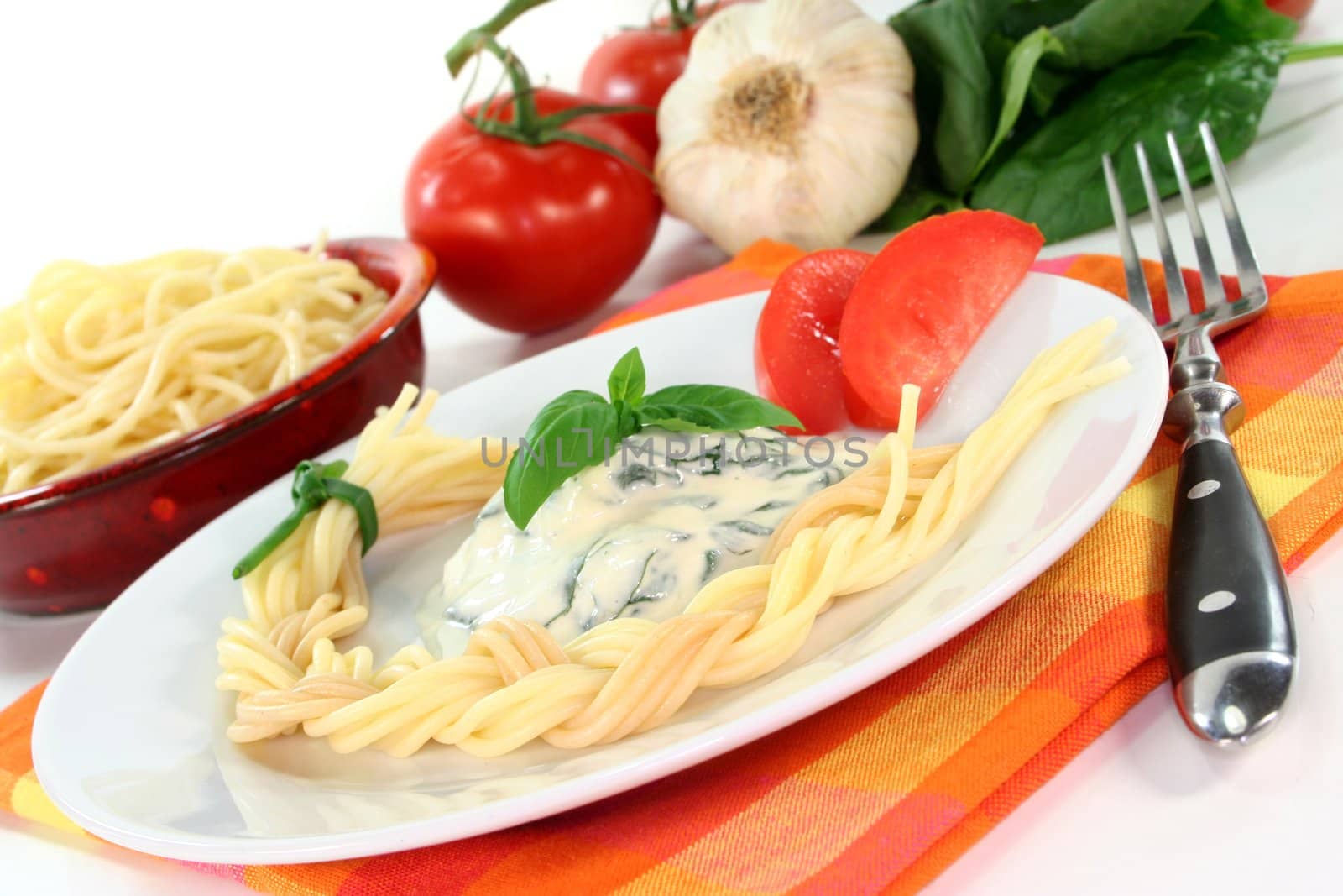 a pasta plait with spinach and cheese sauce with fresh ingredients