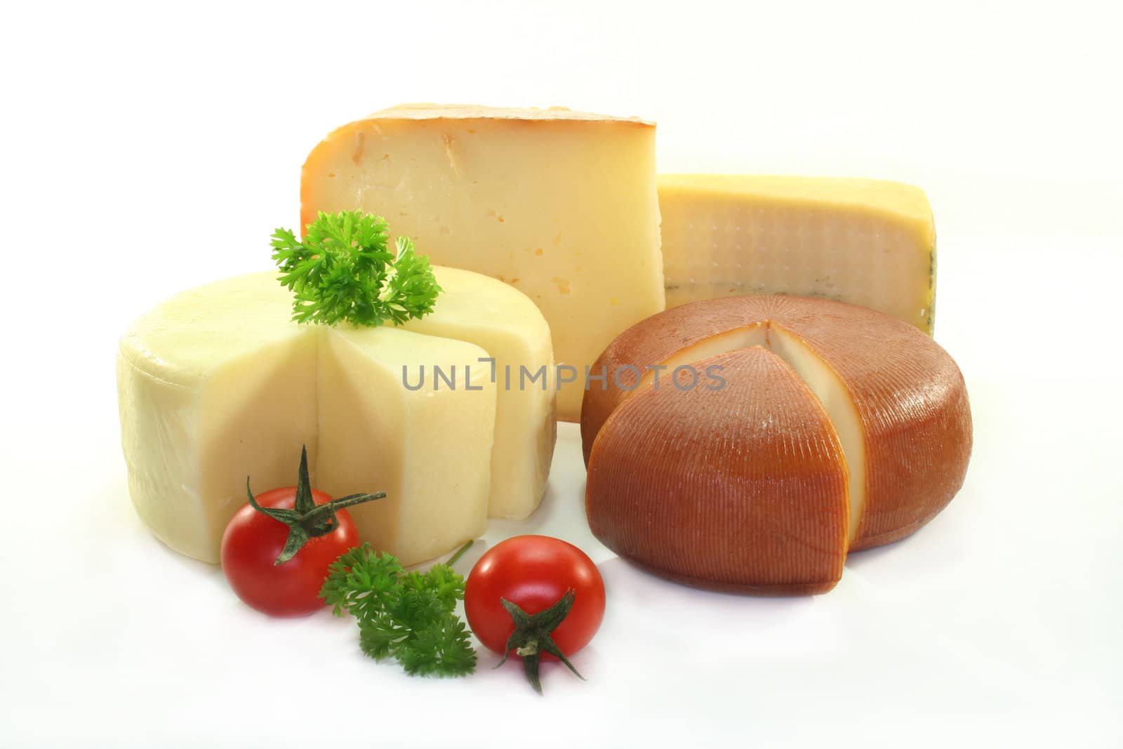 different varieties of cheese with fresh tomatoes and parsley