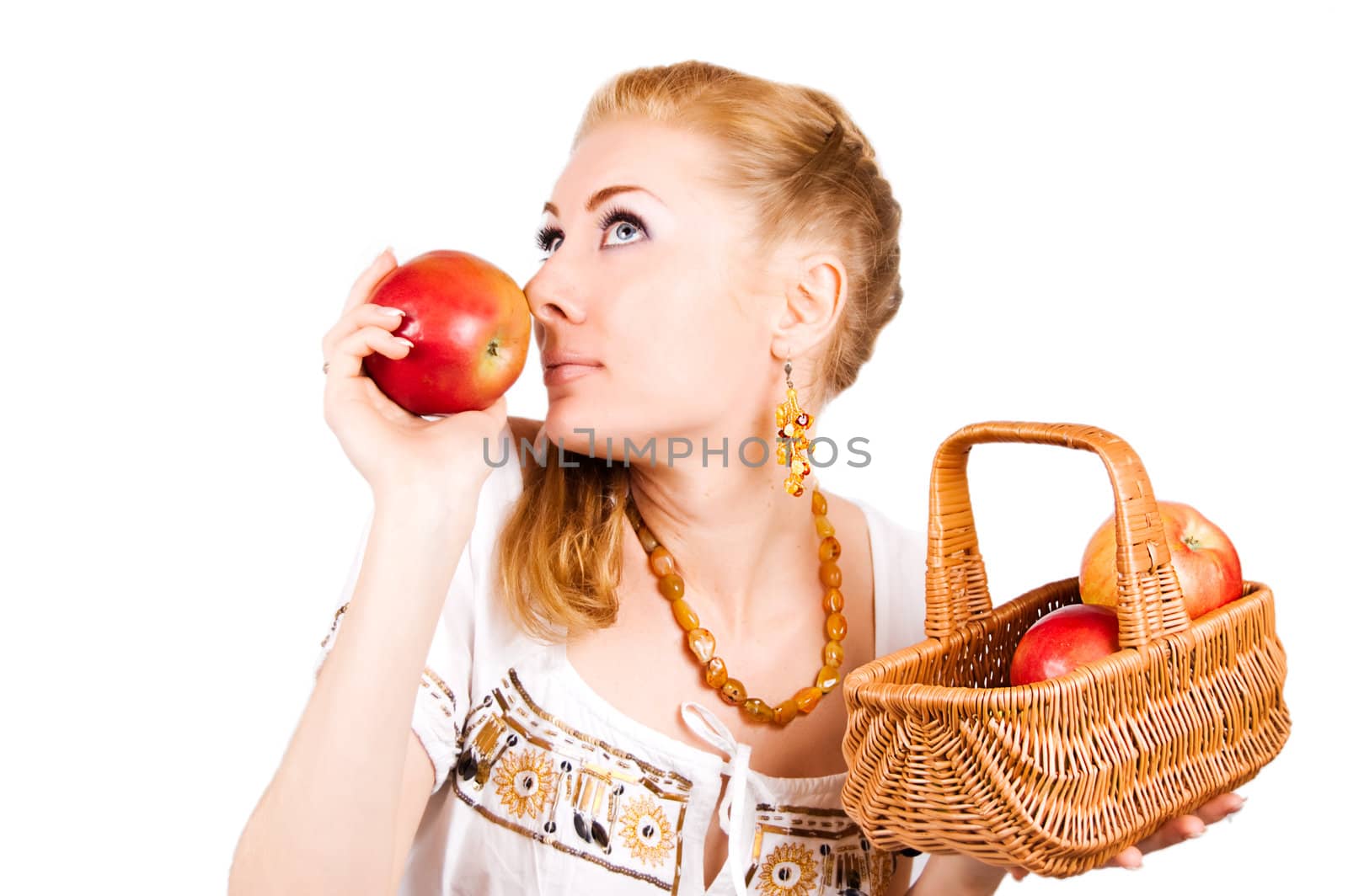 Redheaded woman smelling red apple over white