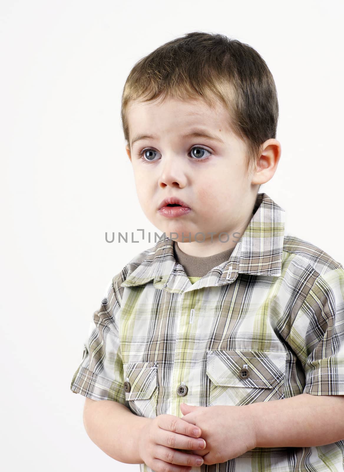 Cute little boy in trouble looking sad, studio shot on white.