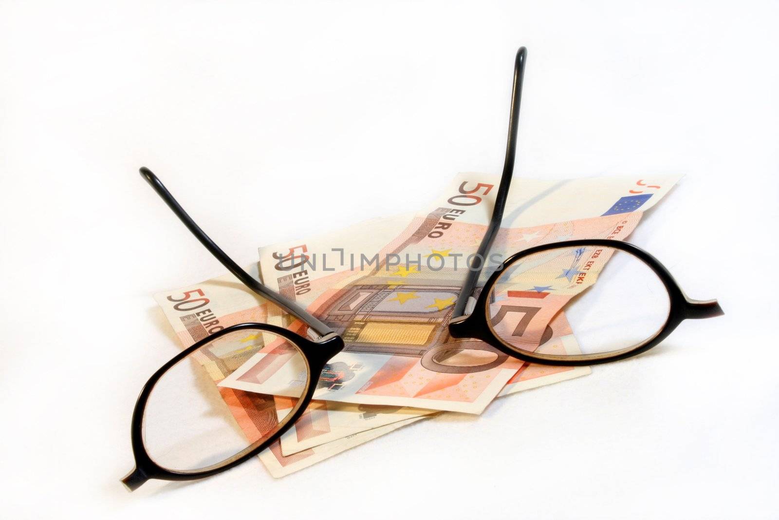 broken glasses and coins against white background
