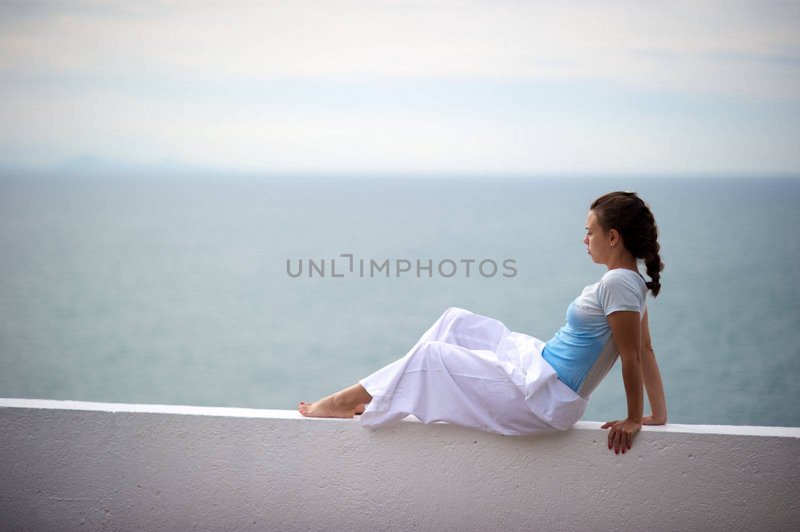 Woman relaxing on a wall in a resort in Porto Belo, Santa Catarina, Brazil