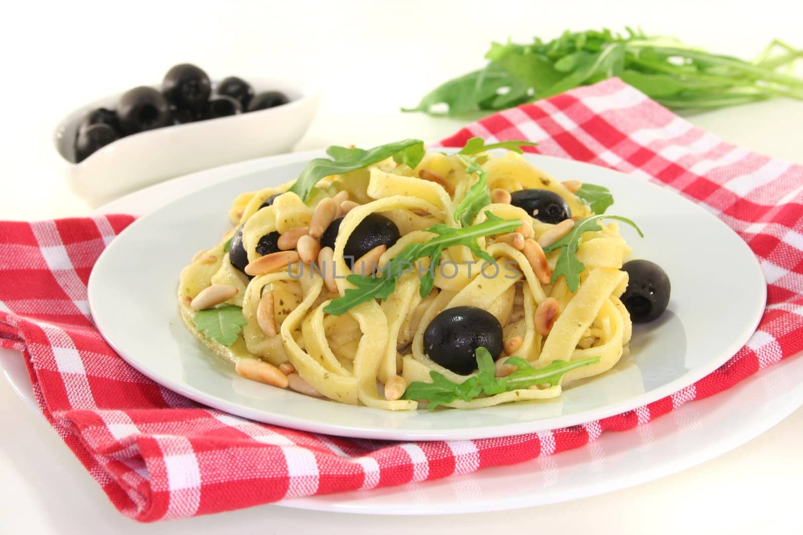 Pasta with pine nuts, pesto, olives and fresh rucola