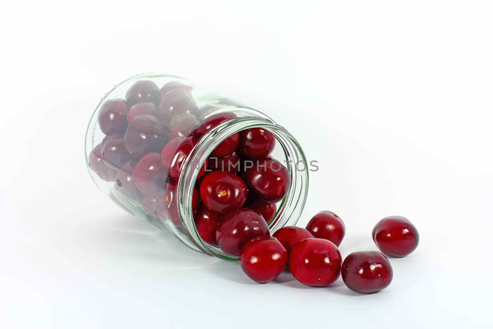 Sweet cherries in glass jar isolated on white