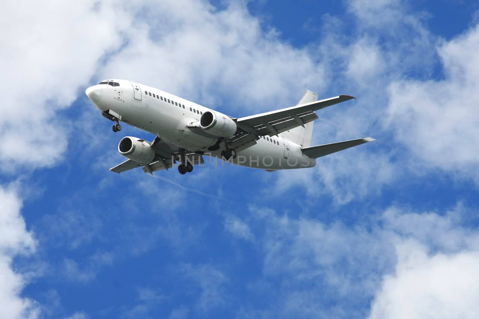 Jet aeroplane for passengers in a blue cloudy sky