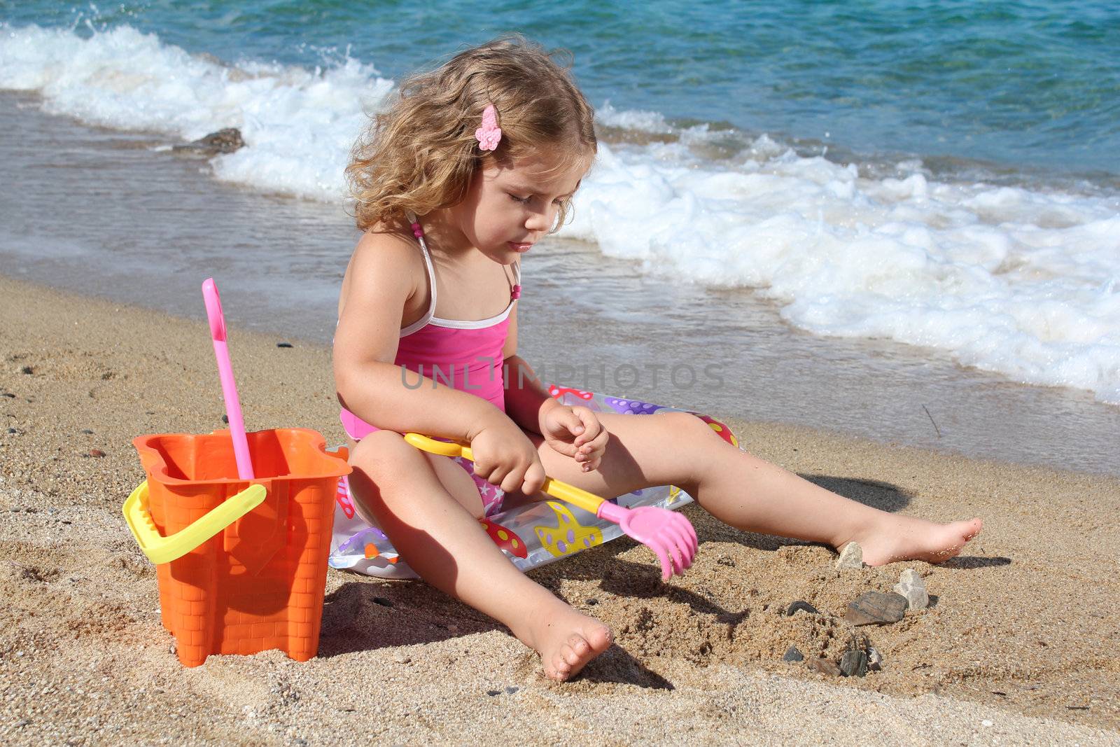 little girl playing on the beach by goce
