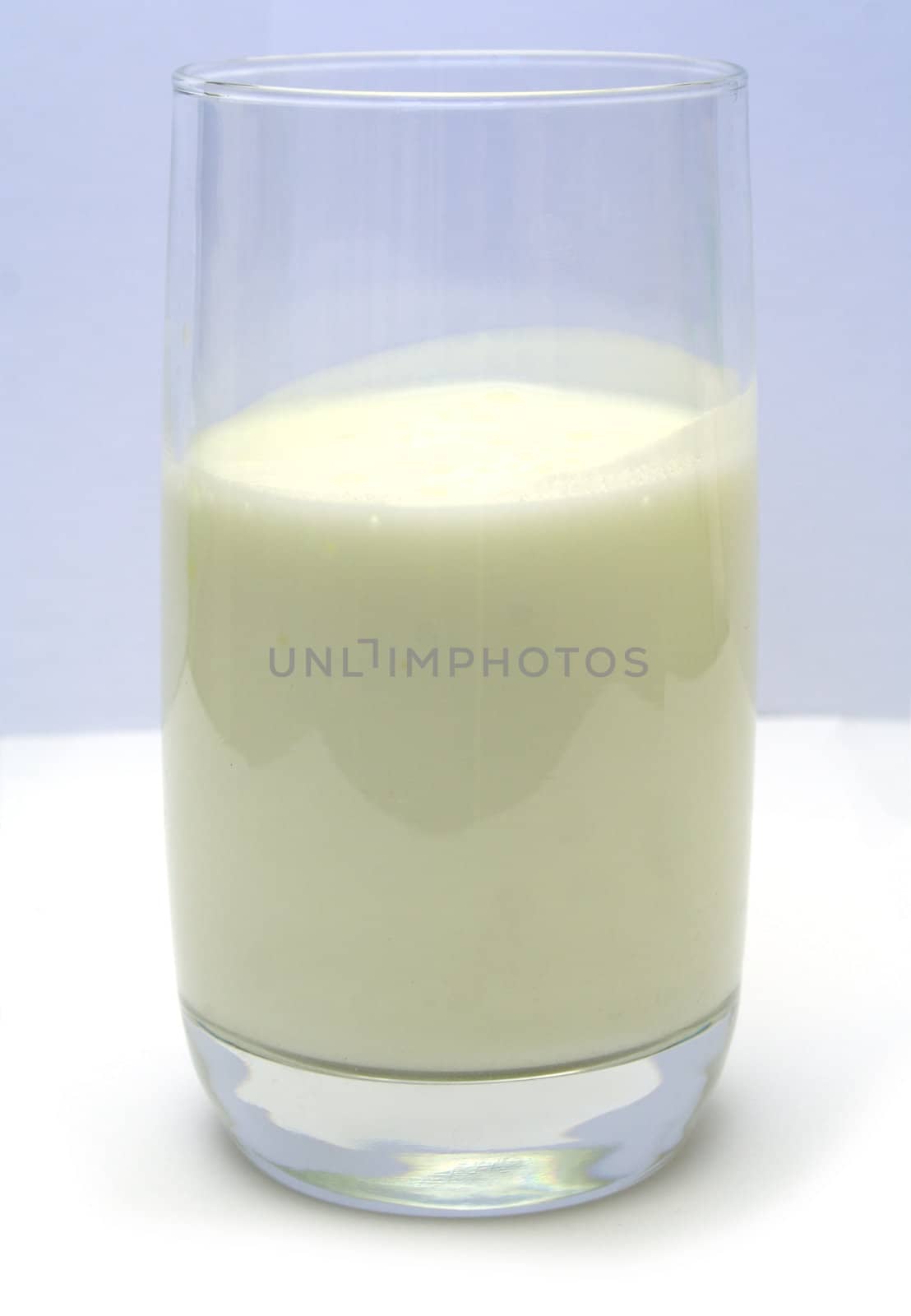 Glass filled with kefir on smooth white table