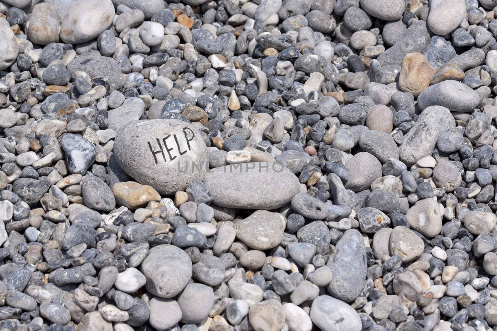 Help written on flintstone on the beach along the coast of Normandie in France