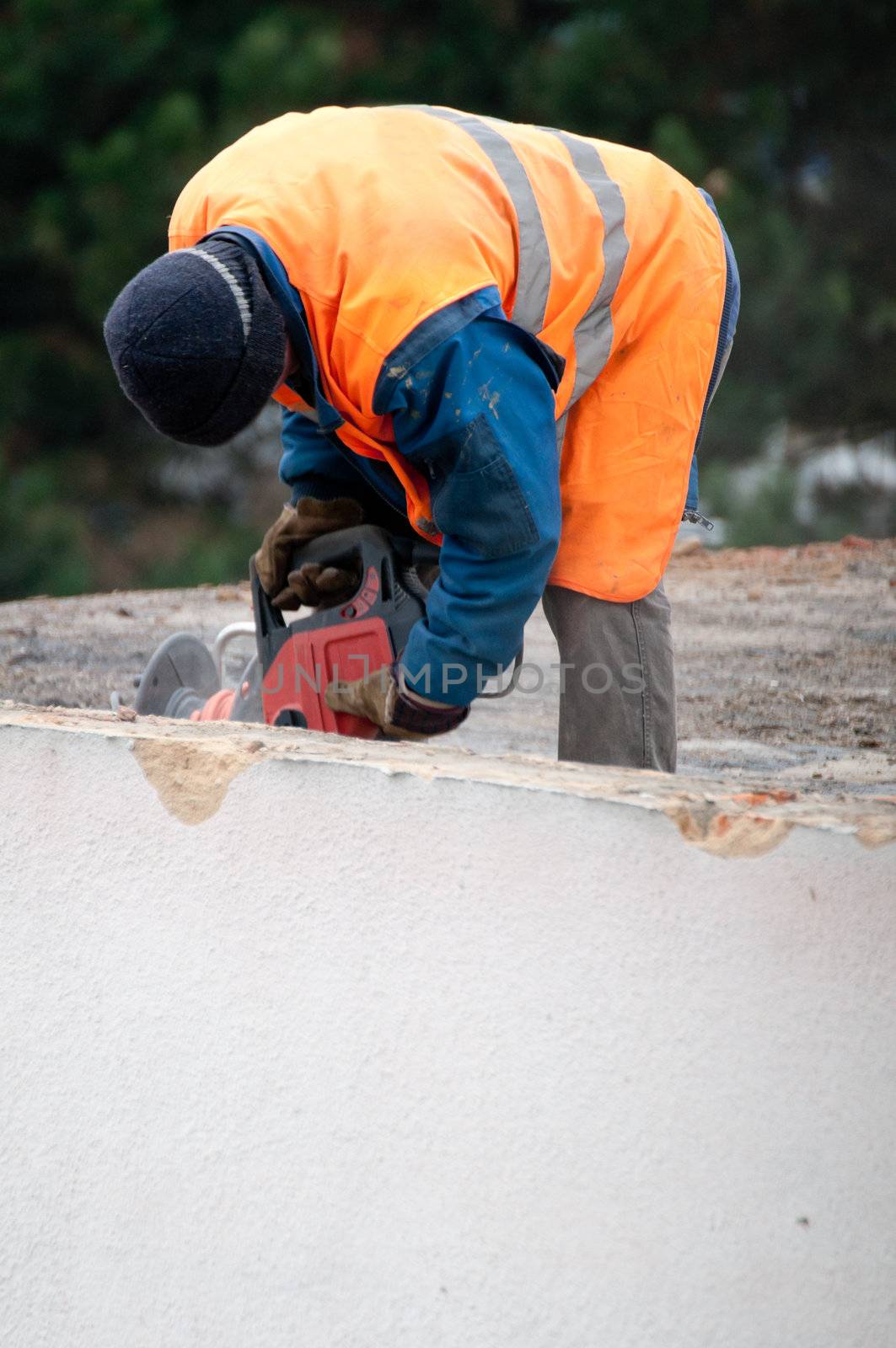 Workman Using Jackhammer on Roof of Building