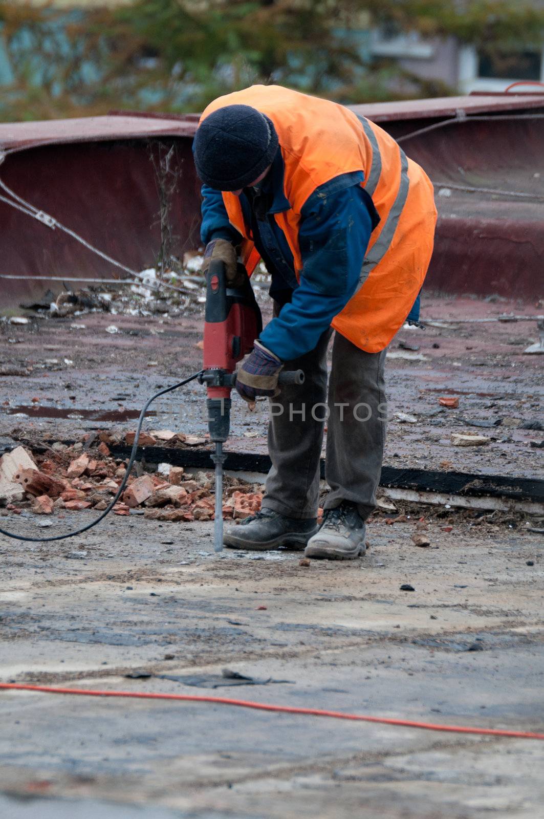 Workman Using Jackhammer on Roof of Building