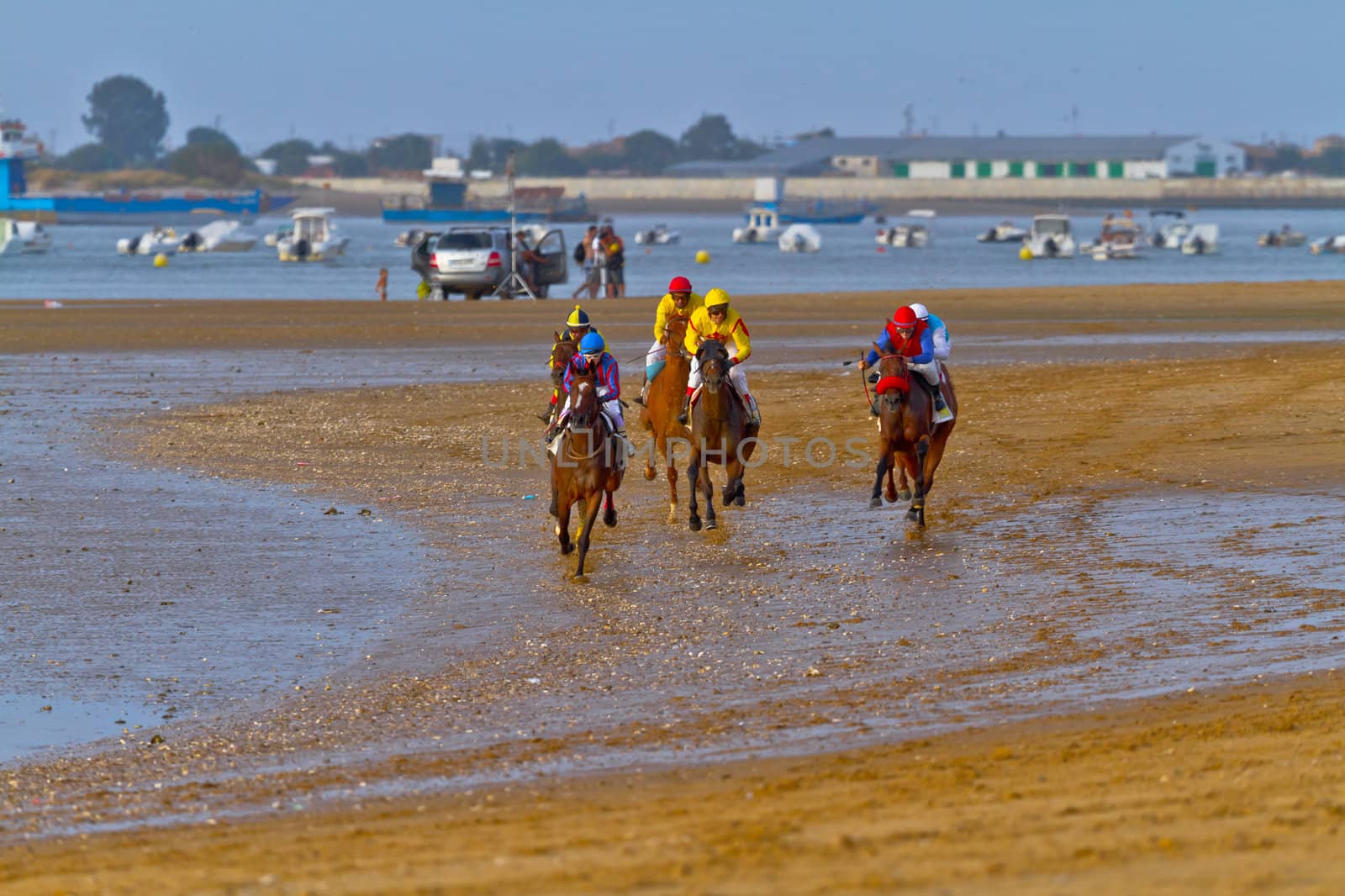 SANLUCAR DE BARRAMEDA, CADIZ, SPAIN - AUGUST 11: Unidentified riders race horses on Sanlucar de Barrameda beach on August 11, 2011 in Sanlucar de Barrameda, Cadiz, Spain.