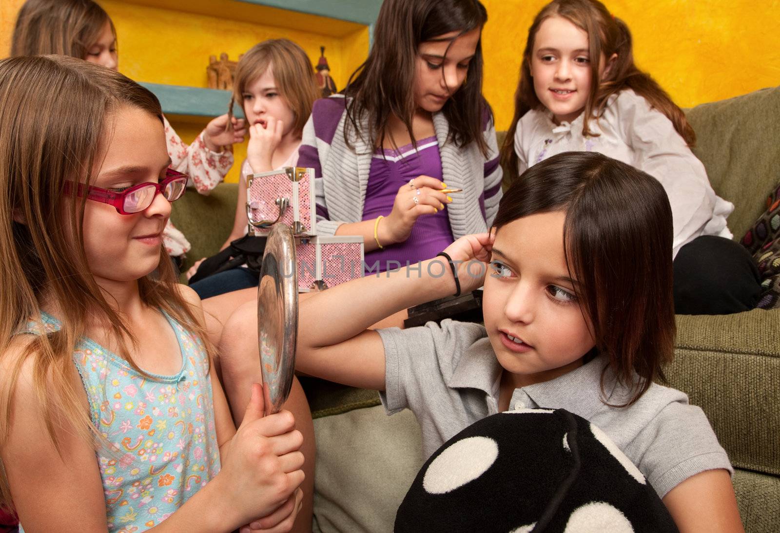 Group of six little girls put on makeup and style their hair 