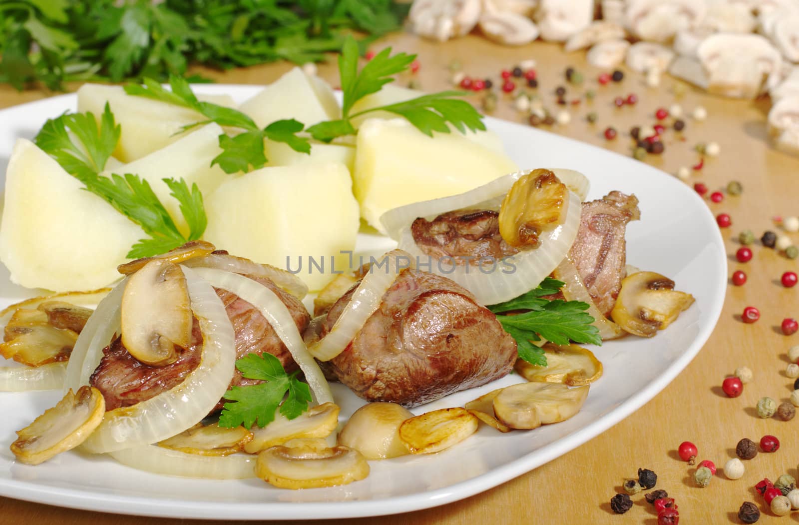 Fillet with mushrooms, onions and potatoes with ingredients in the background