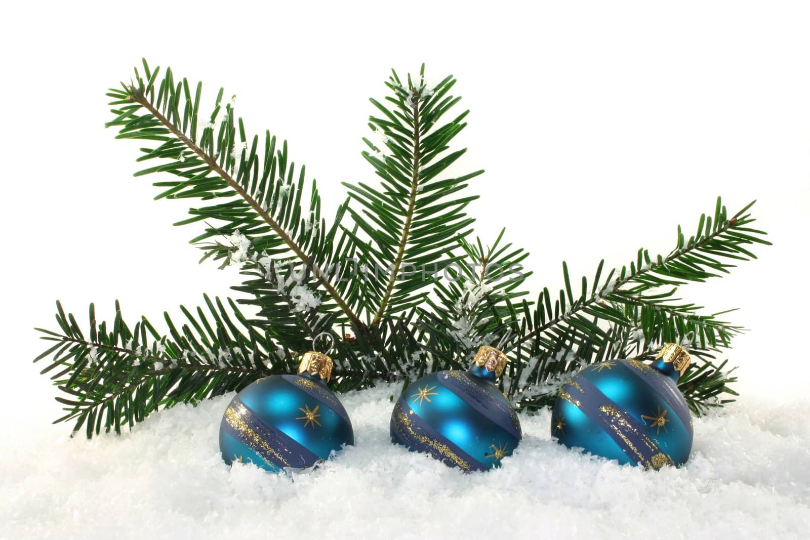 blue Christmas balls and pine branches in the snow