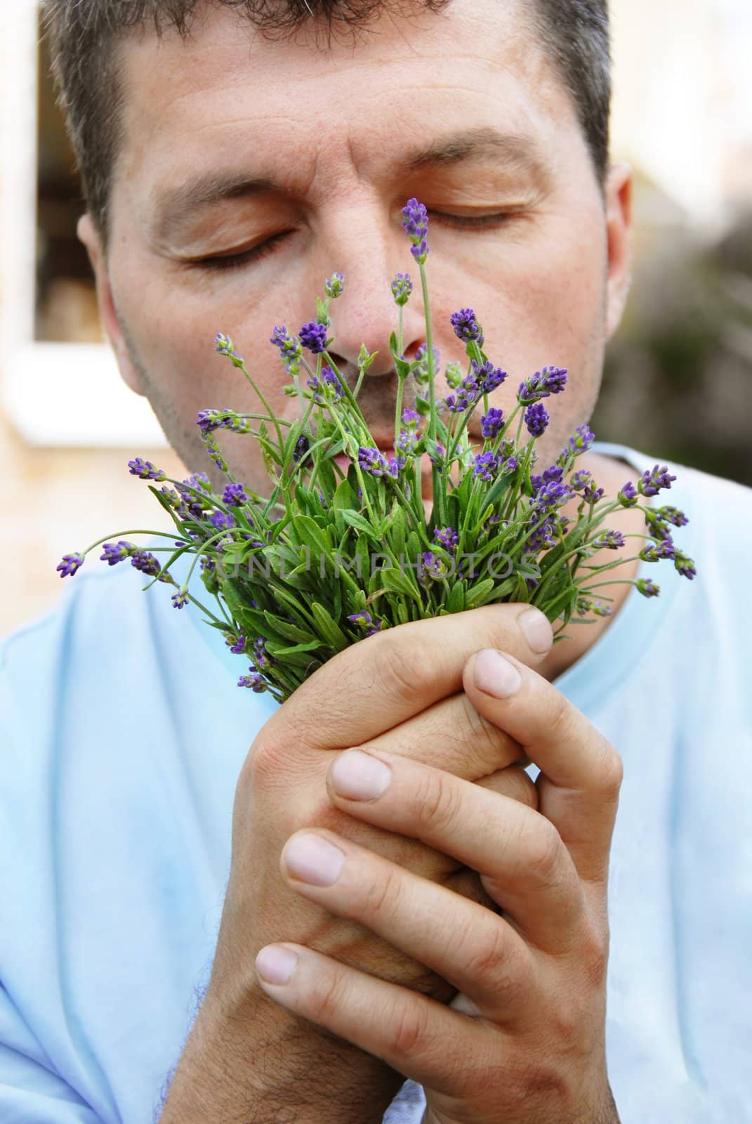 man portrait smelling fresh lavender small bouquet outdoors