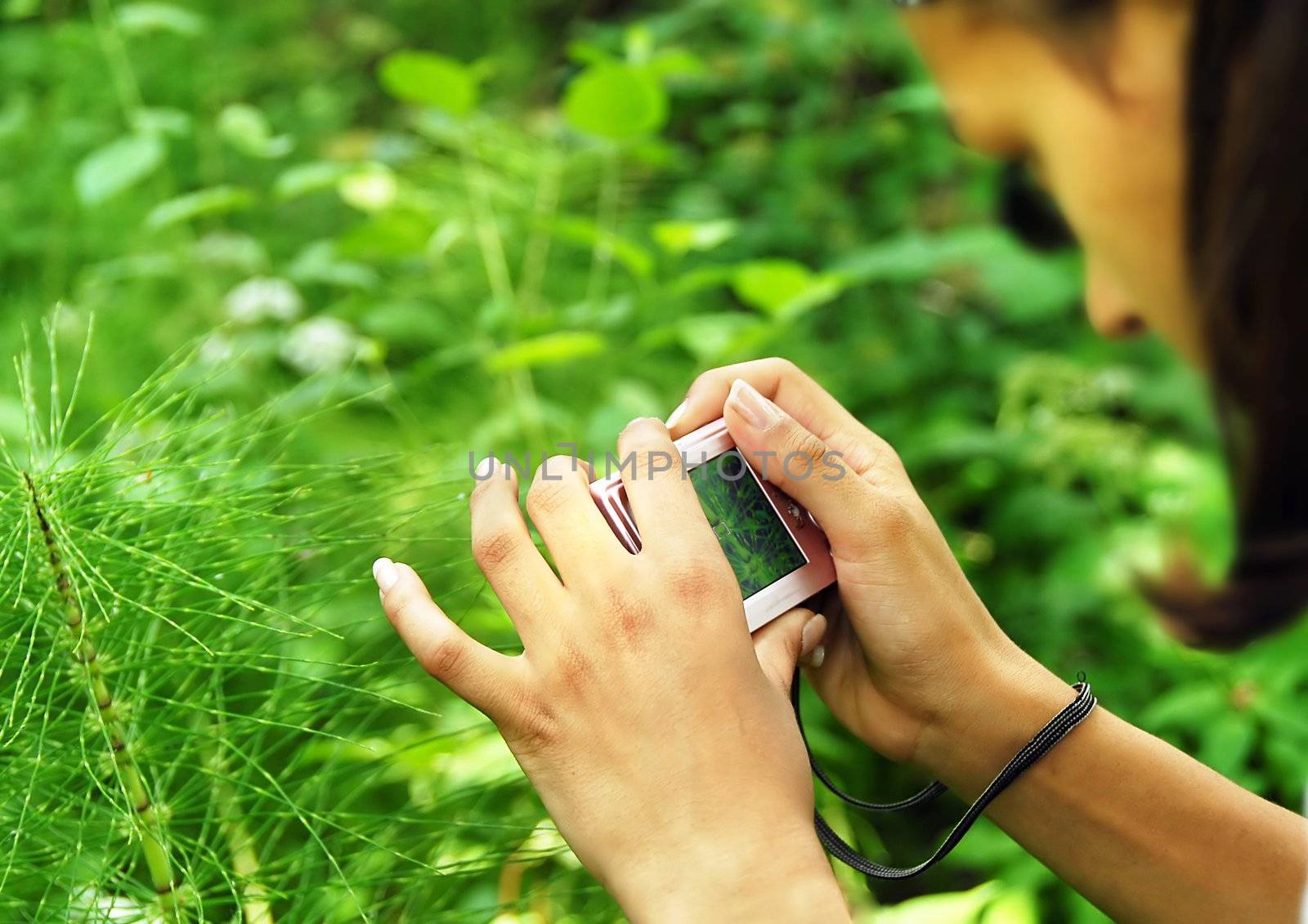 caucasian teenage girl with camera taking a picture outdoors