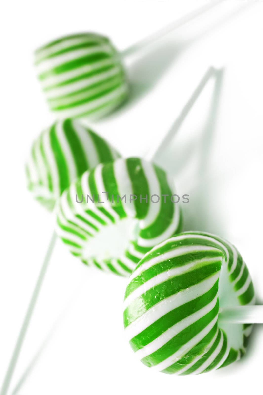 Green and white candy lolly pops on white background by tish1