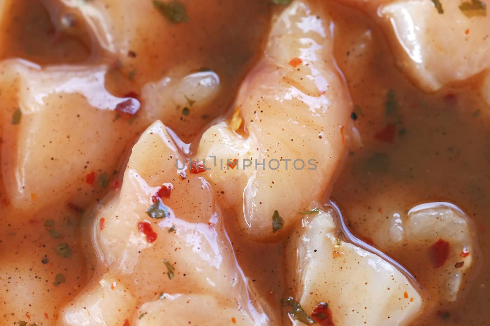 Raw chicken marinating in sauce with lots of spices.