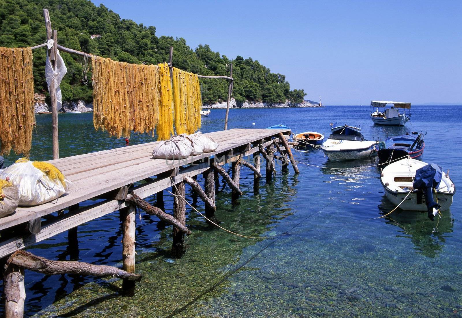 Fishing nets drying on a jetty with fishing boats. Corfu, greece.
