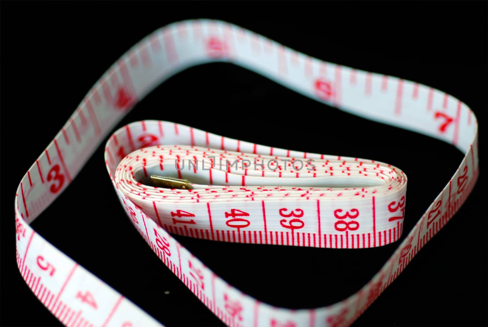 Red and white measuring tape, with numbers.