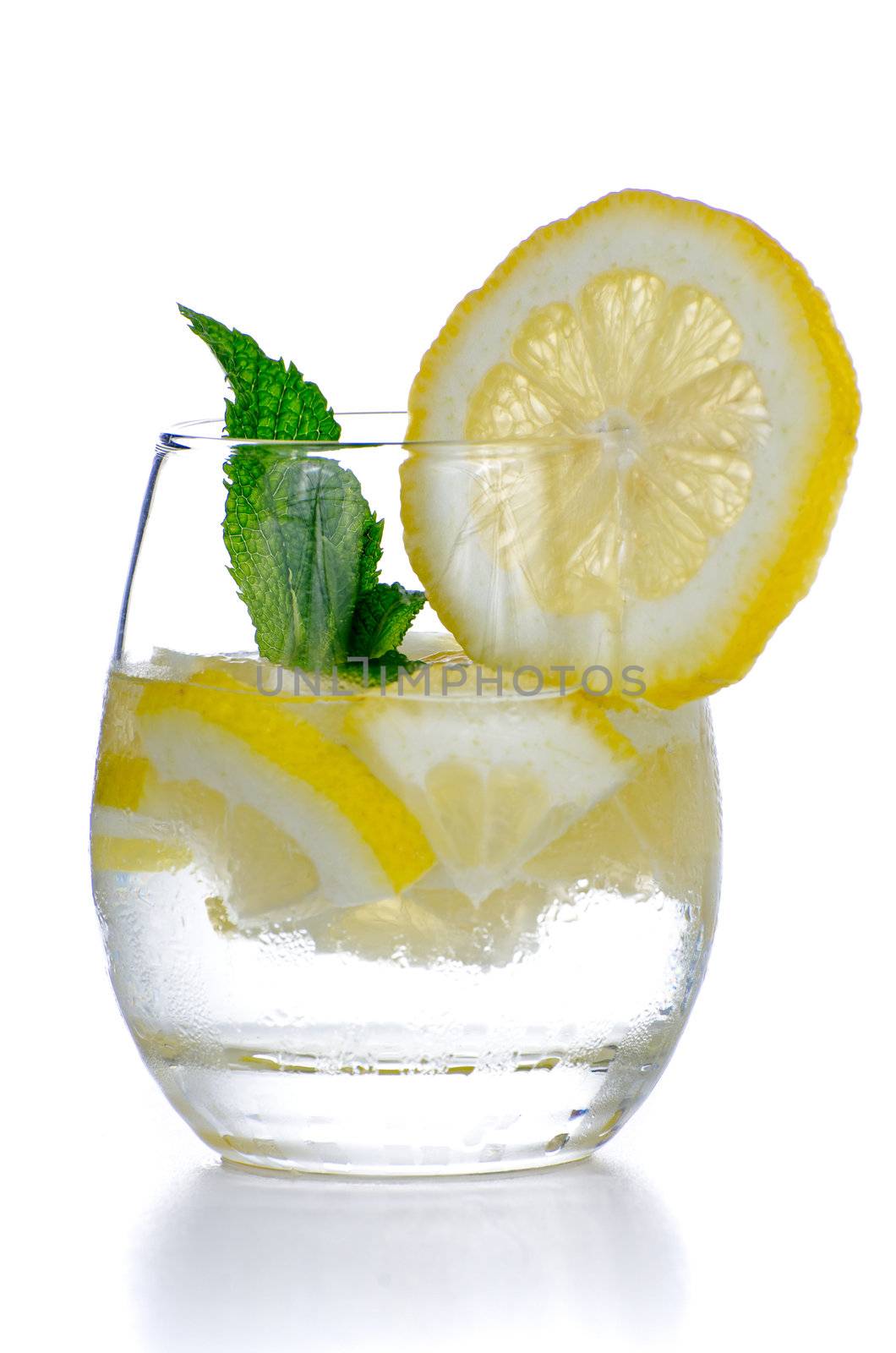 Glass of fresh cool tonic with lime fruits isolated on white background