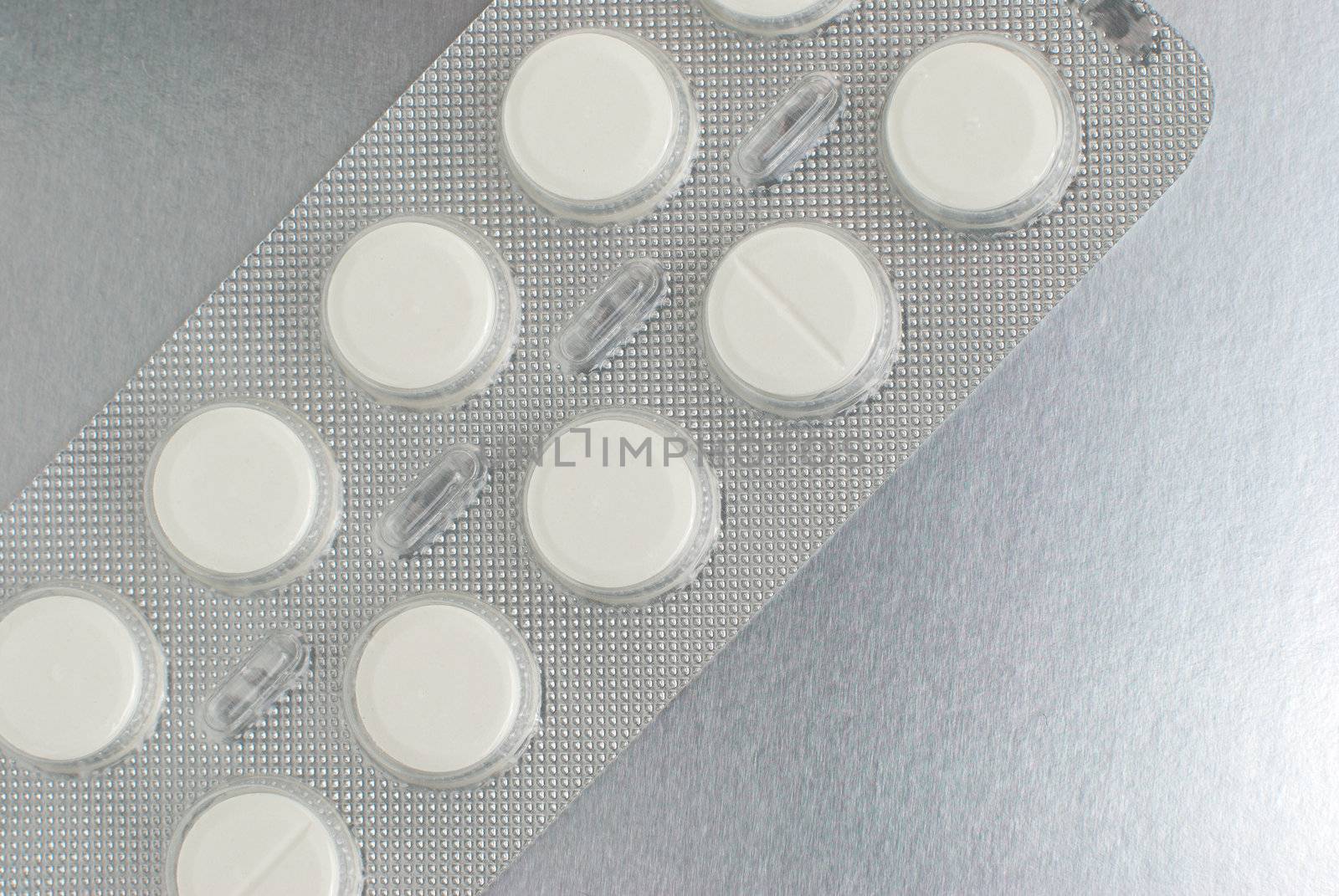 Macro of medical pills on a silver background.