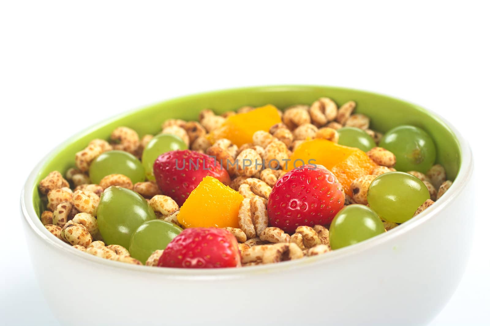 Fresh and healthy breakfast: Fruit salad out of mango, strawberry and white grape with puffed wheat cereal (Selective Focus, Focus on the middle of the bowl) 