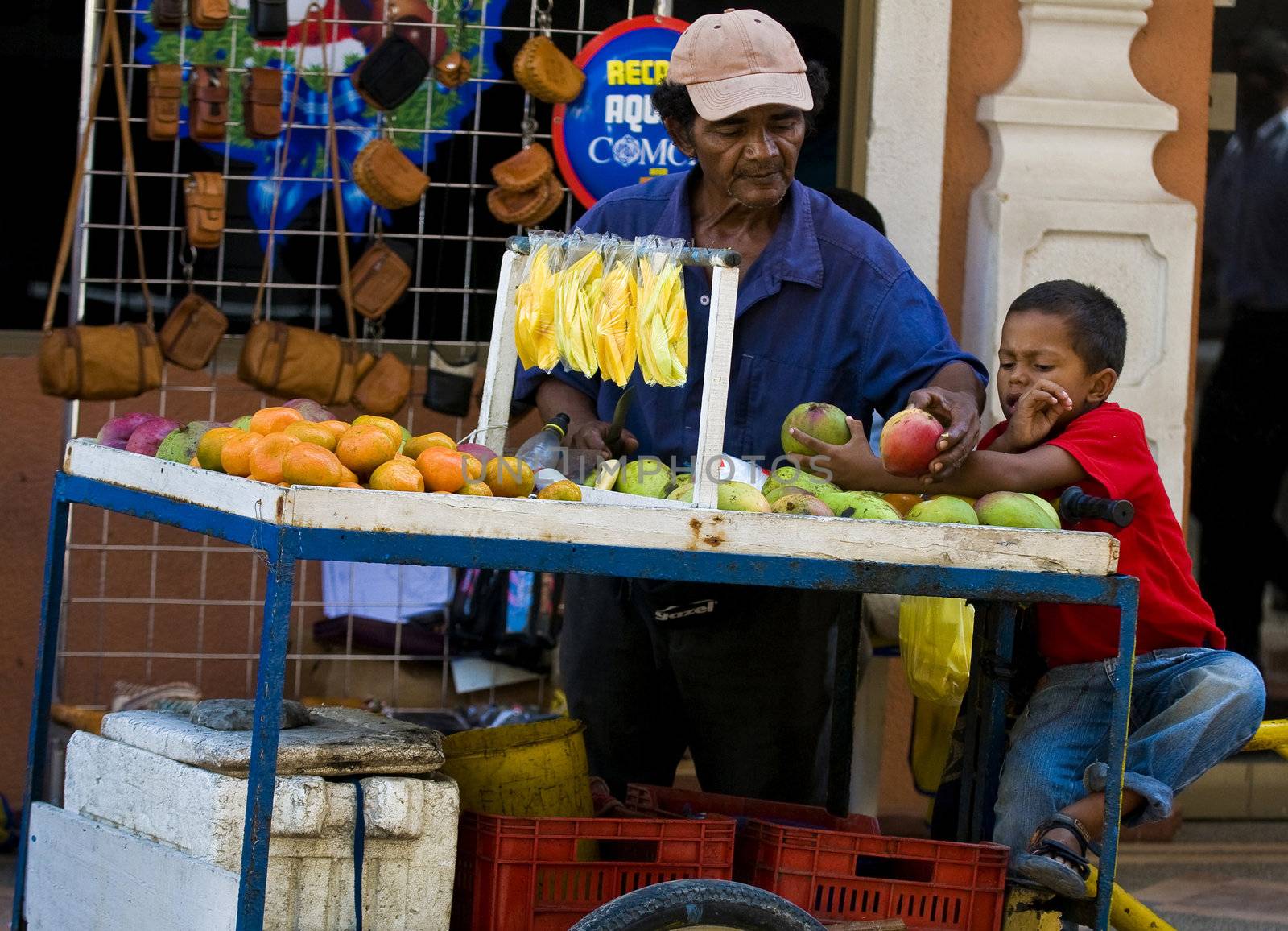 CARTAGENA DE INDIAS , COLOMBIA - DEC 21:Unidentified colombian man with his child, sell fruits in the street in Cartagena de Indias on December 21 2010