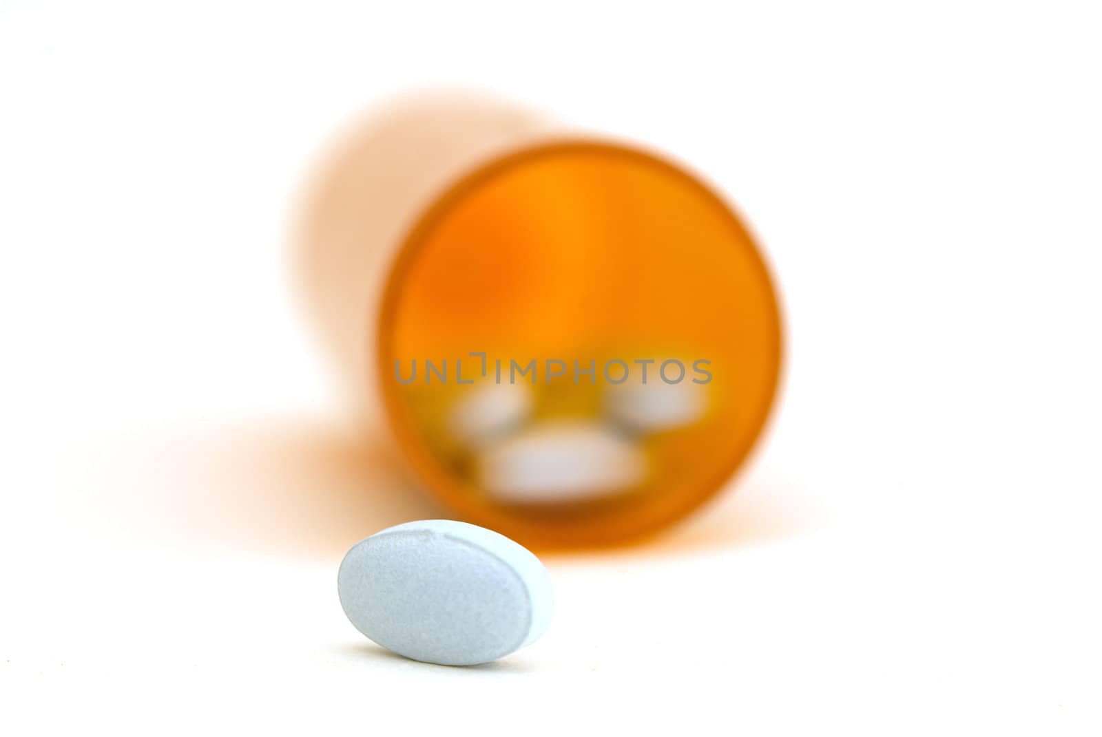 A close up of pills coming out of a bottle on white