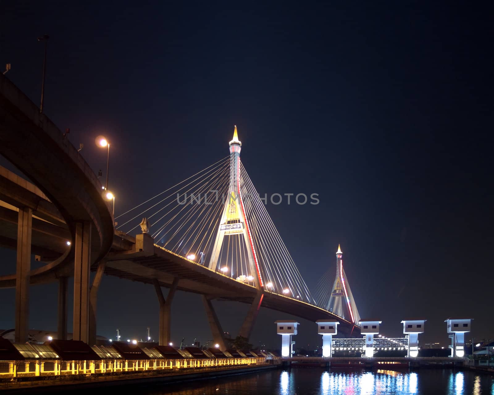 Bhumibol Bridge also casually call as Industrial Ring Road Bridge with floodgate illuminate with spotlight at night scene, Samut Prakarn, Thailand