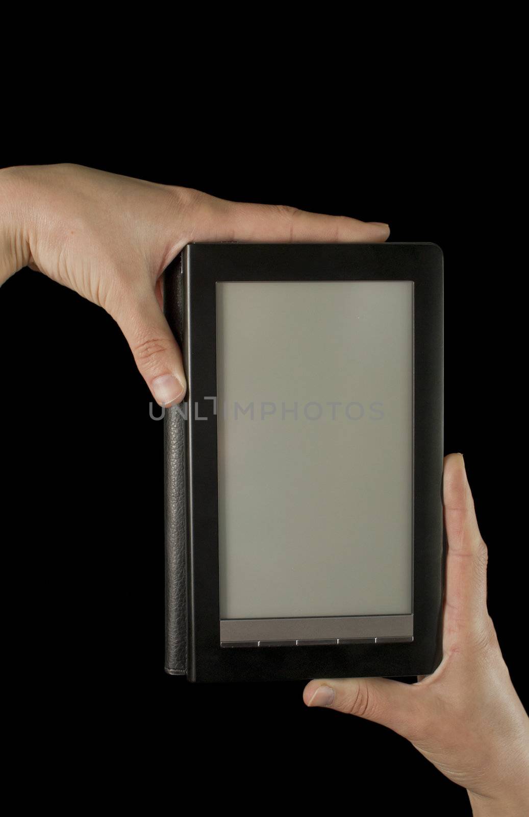 Hands holding an electronic book reader on the black background