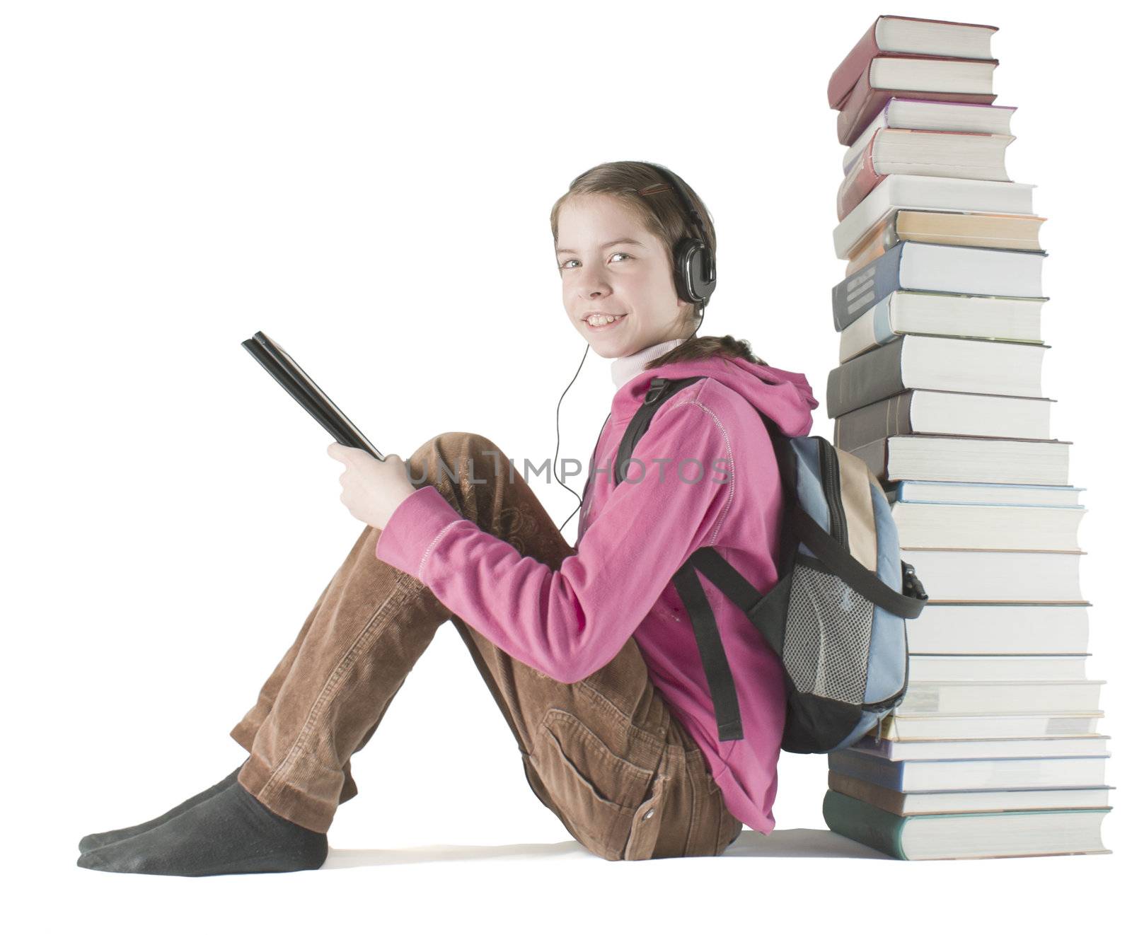 Teen girl reads ebook sitting near the stack of printed books by AndreyKr