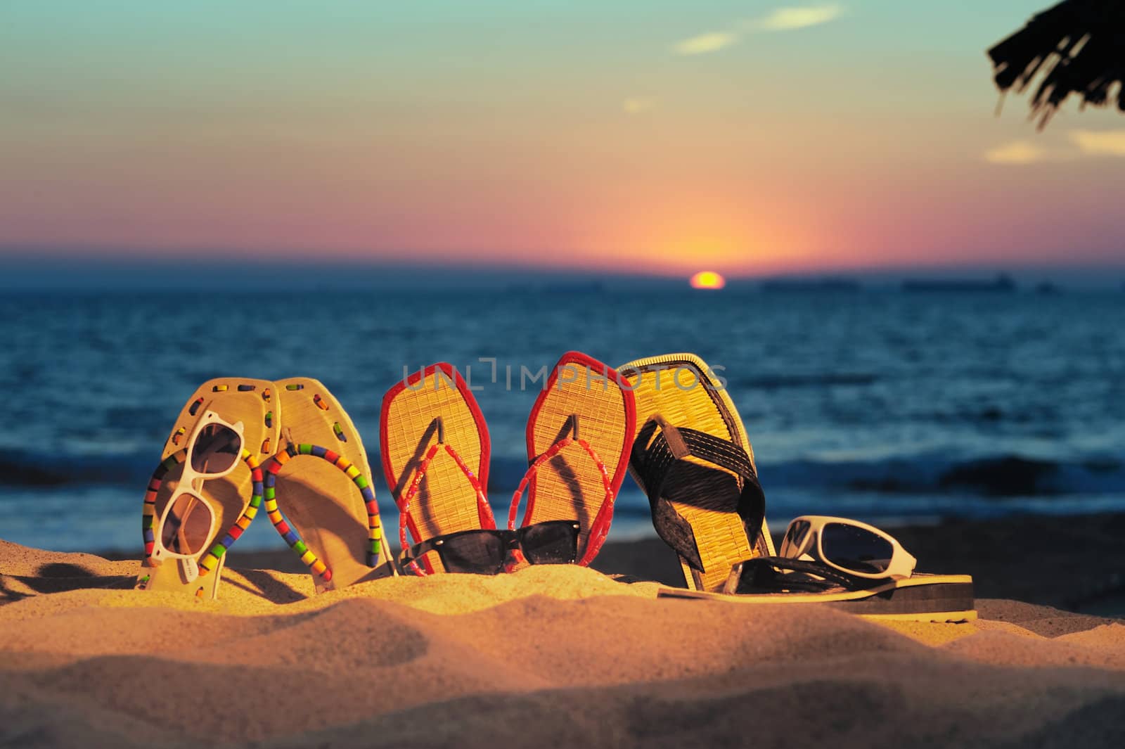 Beach sandals and glasses on the beach in evening