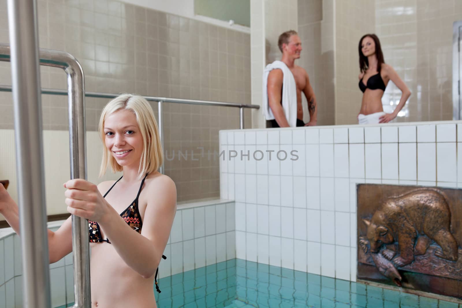 Portrait of pretty blond girl in the pool by leaf