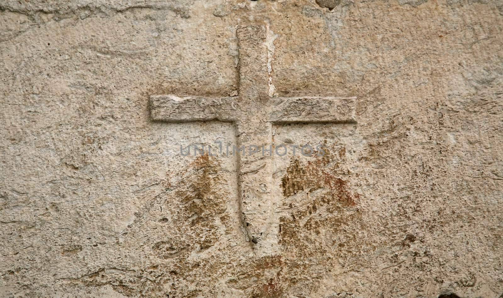Cross on the wall by atlas