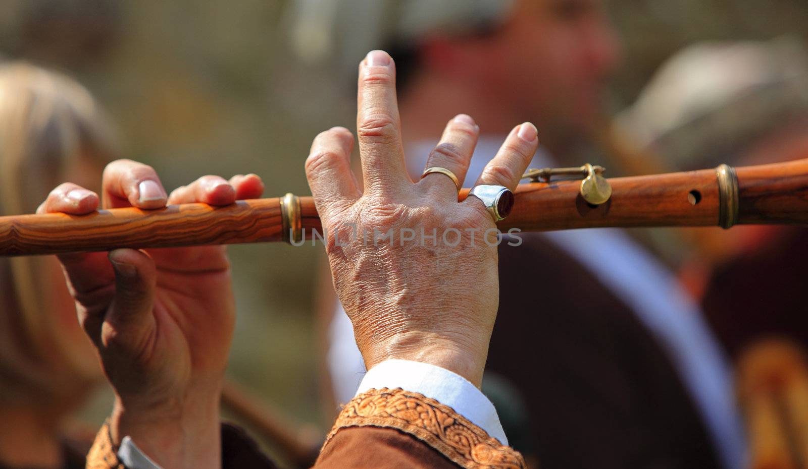  Detail of hands of a flute player during a medieval music performance. 