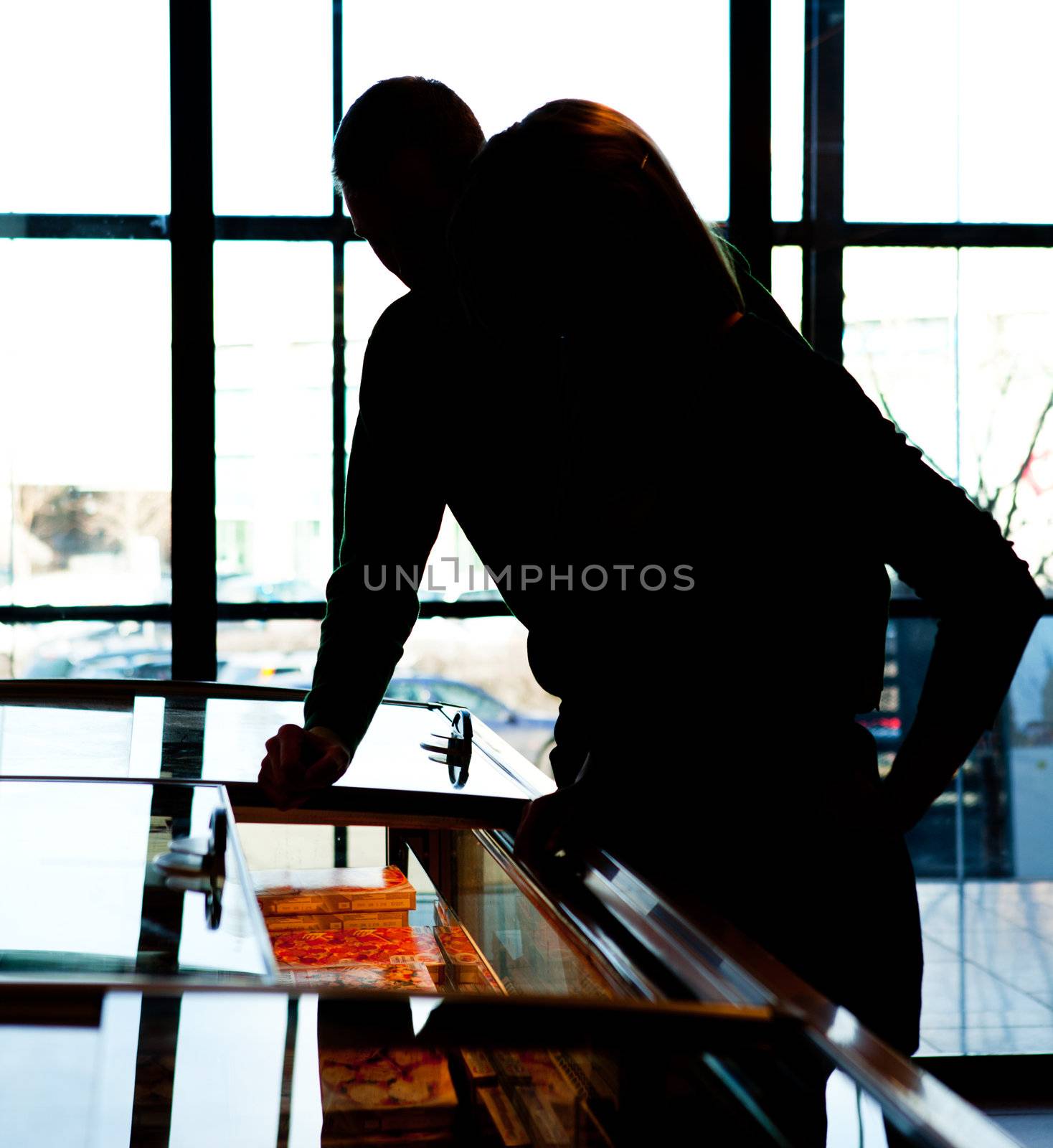 A man and woman in the frozen food section of a supermarket