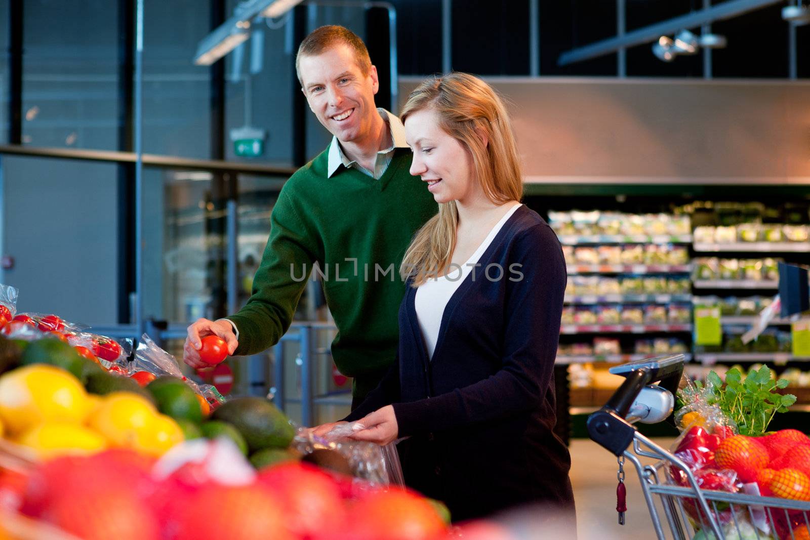 A happy couple buying fresh produce in a supermarket