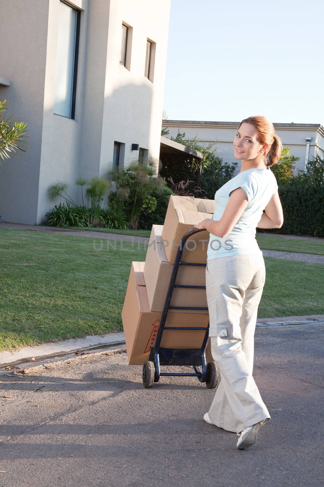 Portrait of an pretty woman with stack of box moving to a new house