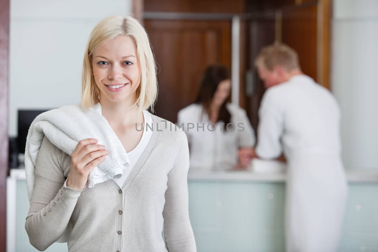 Pretty woman with people in background at spa by leaf