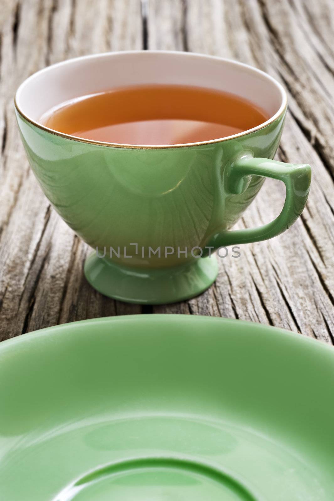 Two antiques cups with tea on a rustic background