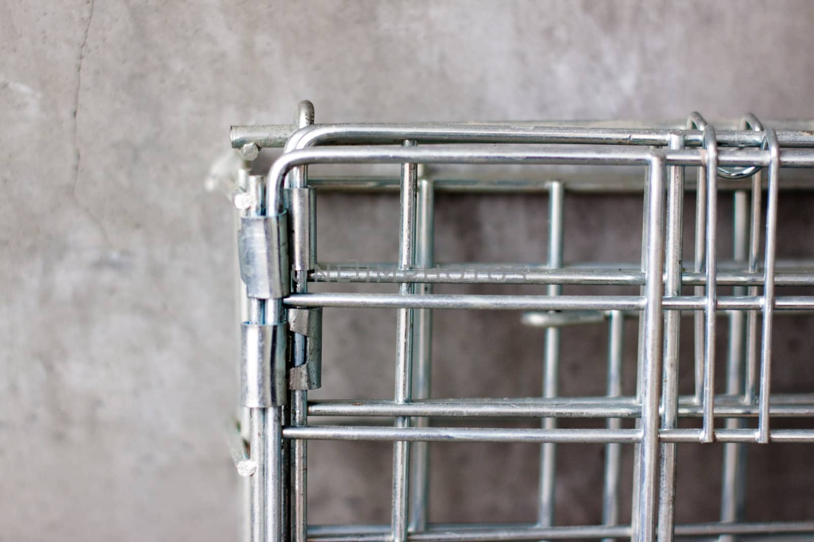 A metal lattice near a concrete wall
