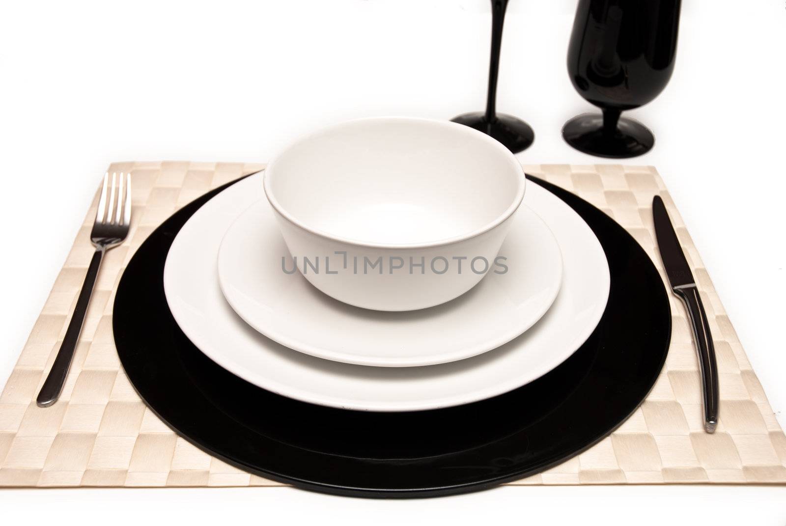 Service plates in black and white, with plate, glasses, cutlery