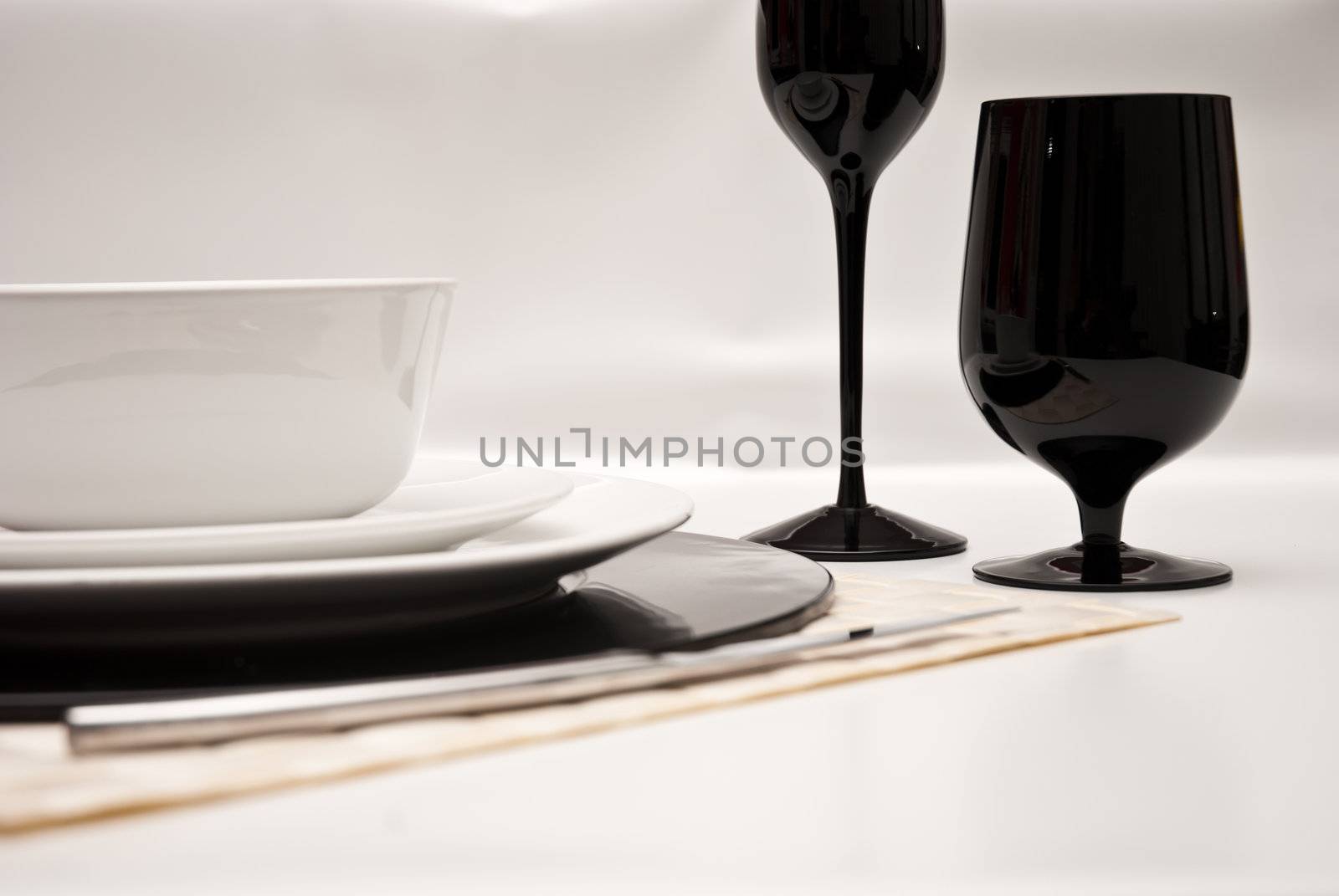 Service plates in black and white, with plate, glasses, cutlery