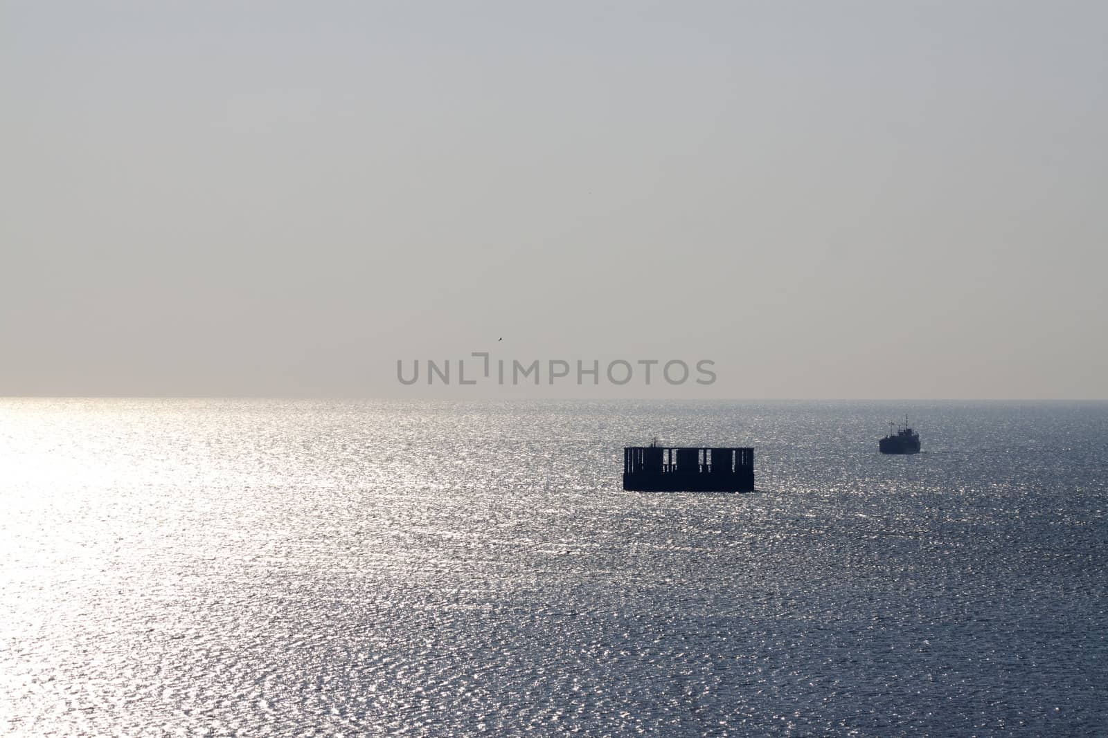 Ship sailing in the gold and silver reflection of the  sunset